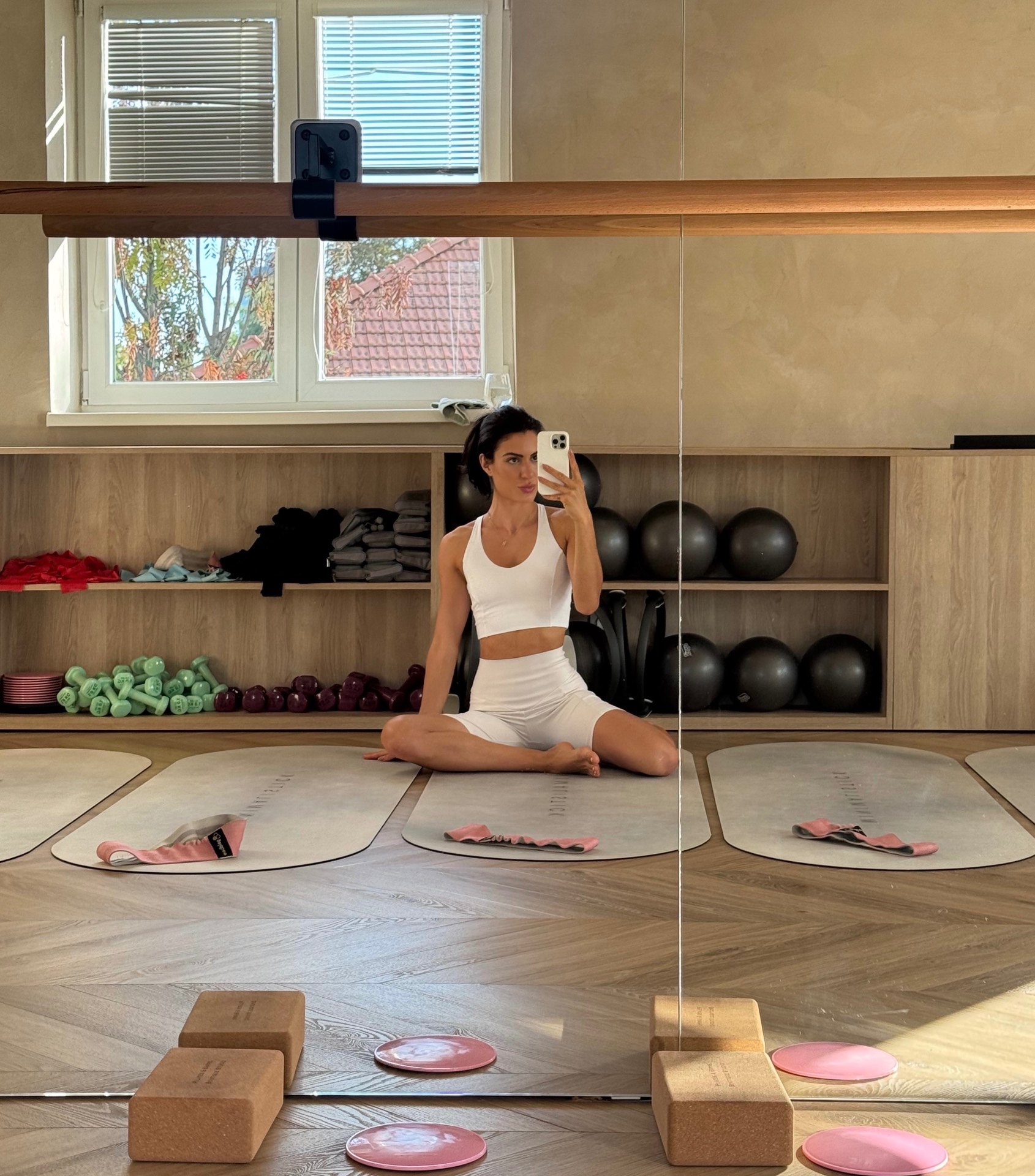Romana Holly stretching in a light filled pilates studio